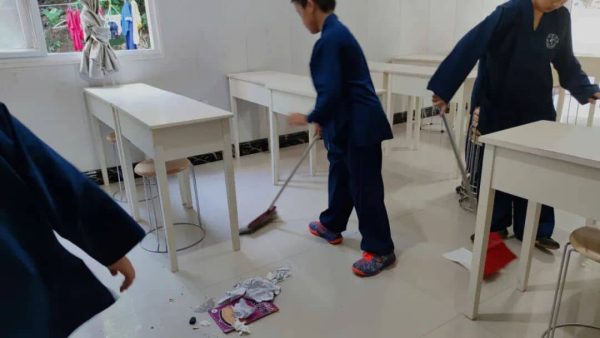 image shows students cleaning the classroom to learn Taoist culture and humility